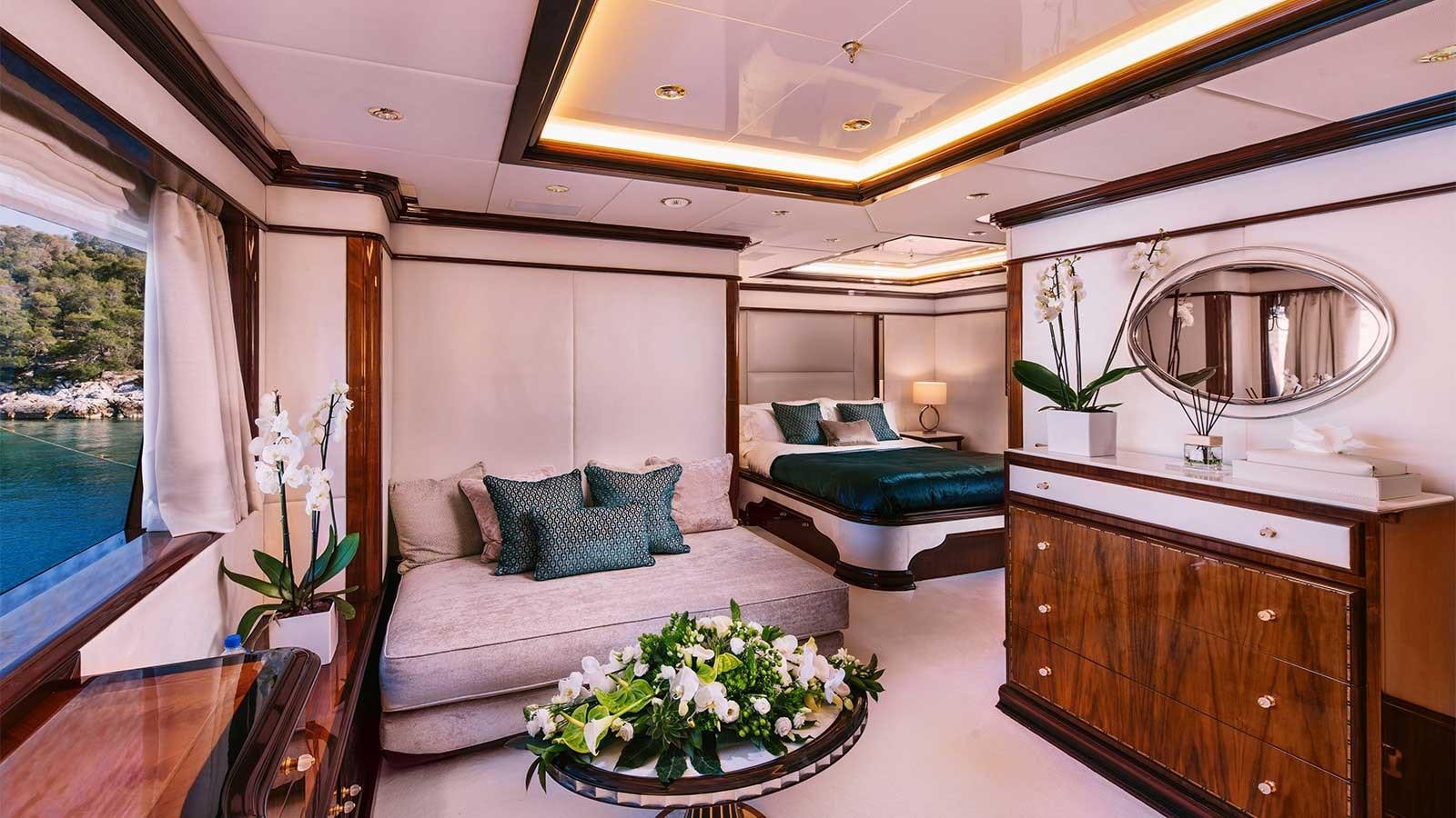 a room with a bed and a couch aboard IDYLLIC Yacht for Charter