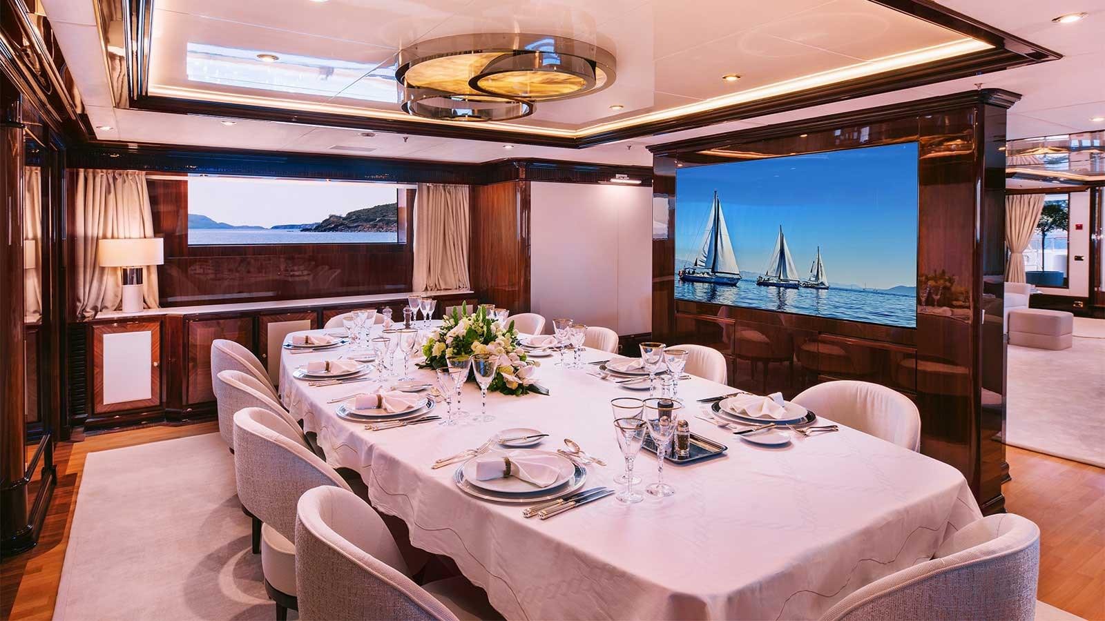 a large dining table with white cloths and chairs aboard IDYLLIC Yacht for Charter
