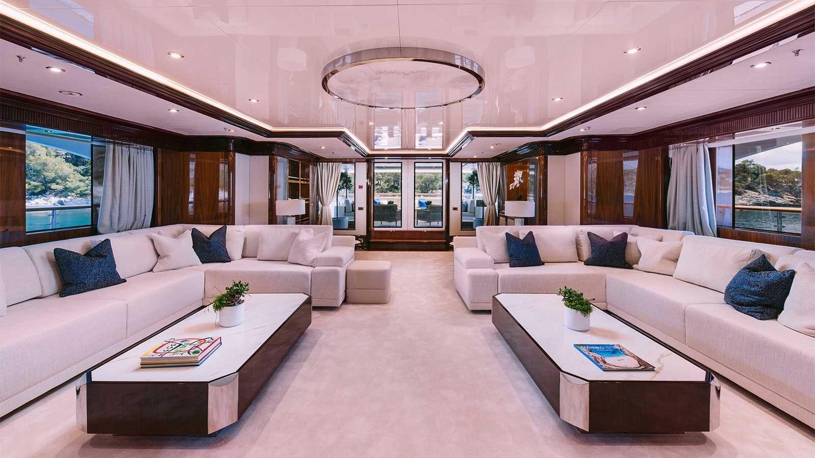a living room with a large white couch and a large window aboard IDYLLIC Yacht for Charter