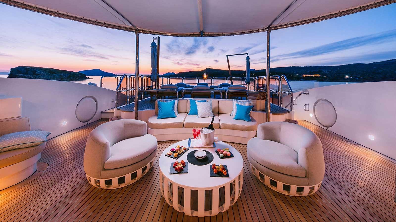 a room with a table chairs and a view of the ocean aboard IDYLLIC Yacht for Charter