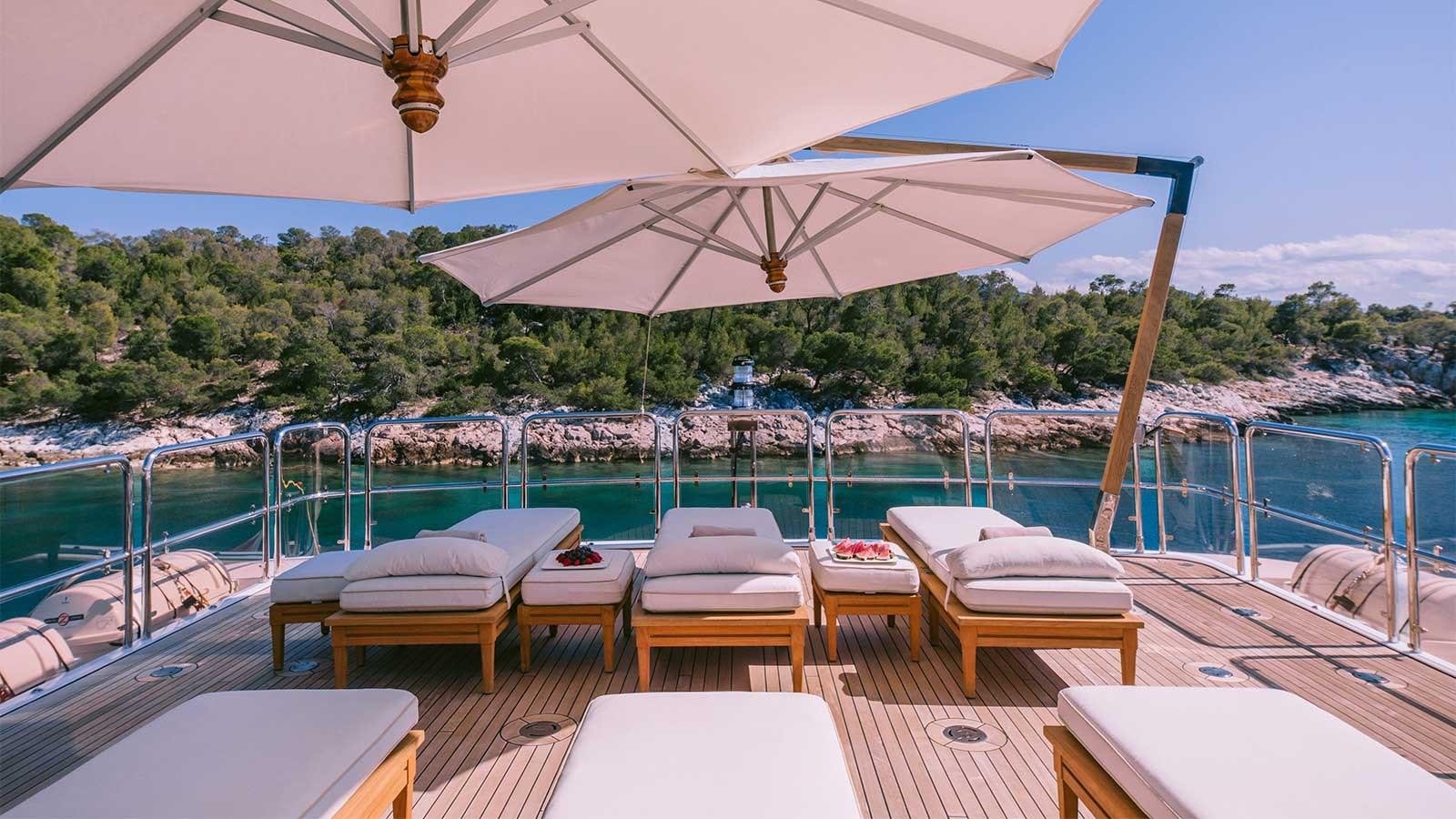 a lounge area on a deck overlooking a city aboard IDYLLIC Yacht for Charter