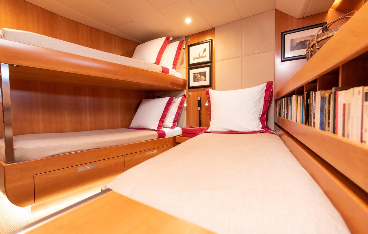 a bed with a white pillow and red pillows aboard SILVERTIP Yacht for Sale