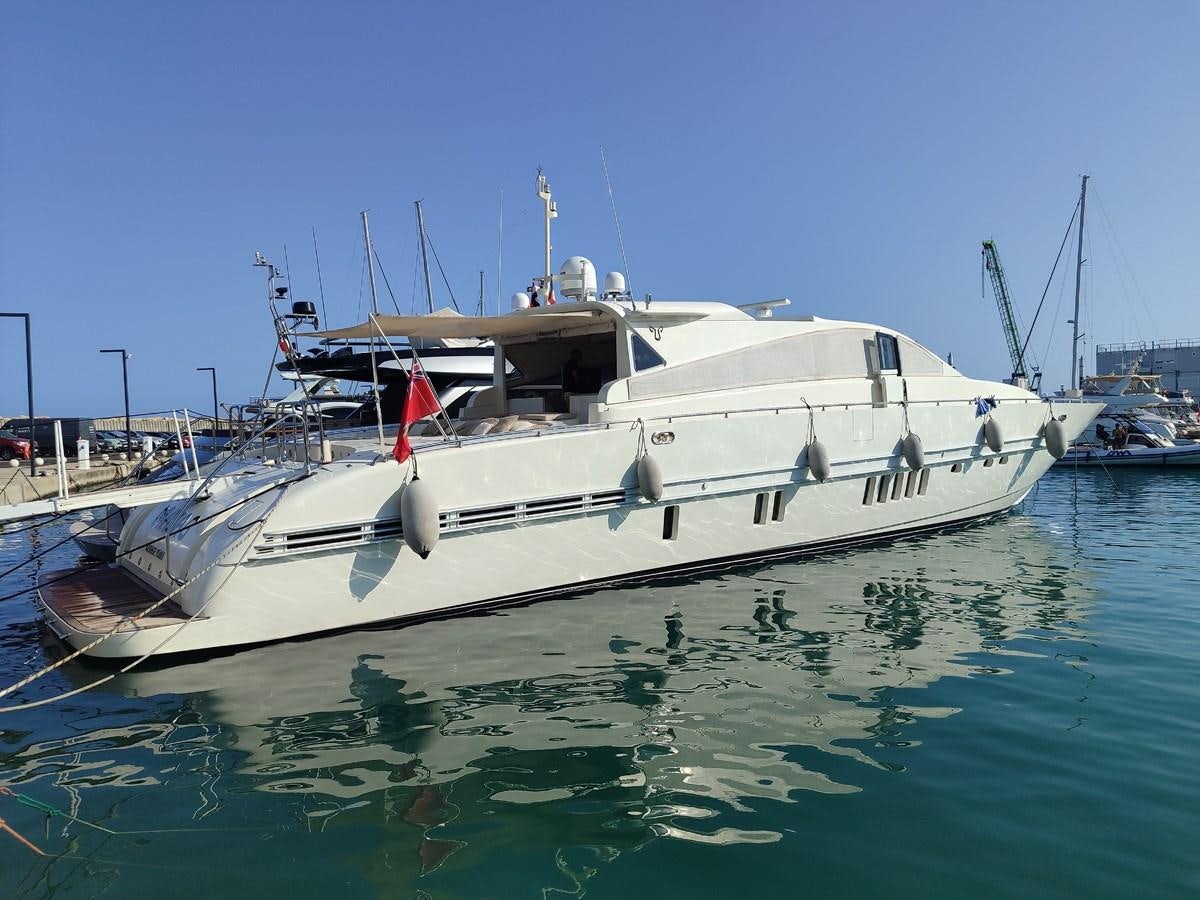 a boat in the water with USS Potomac (AG-25) in the background aboard MAZAG Yacht for Sale