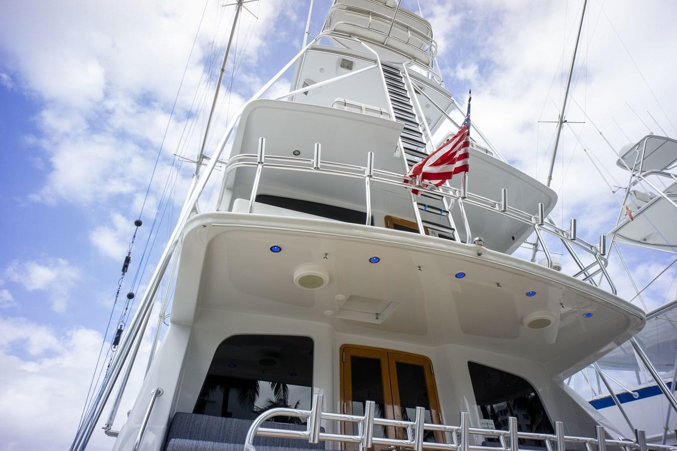 a white boat with a flag on the front aboard REEL DEAL Yacht for Sale