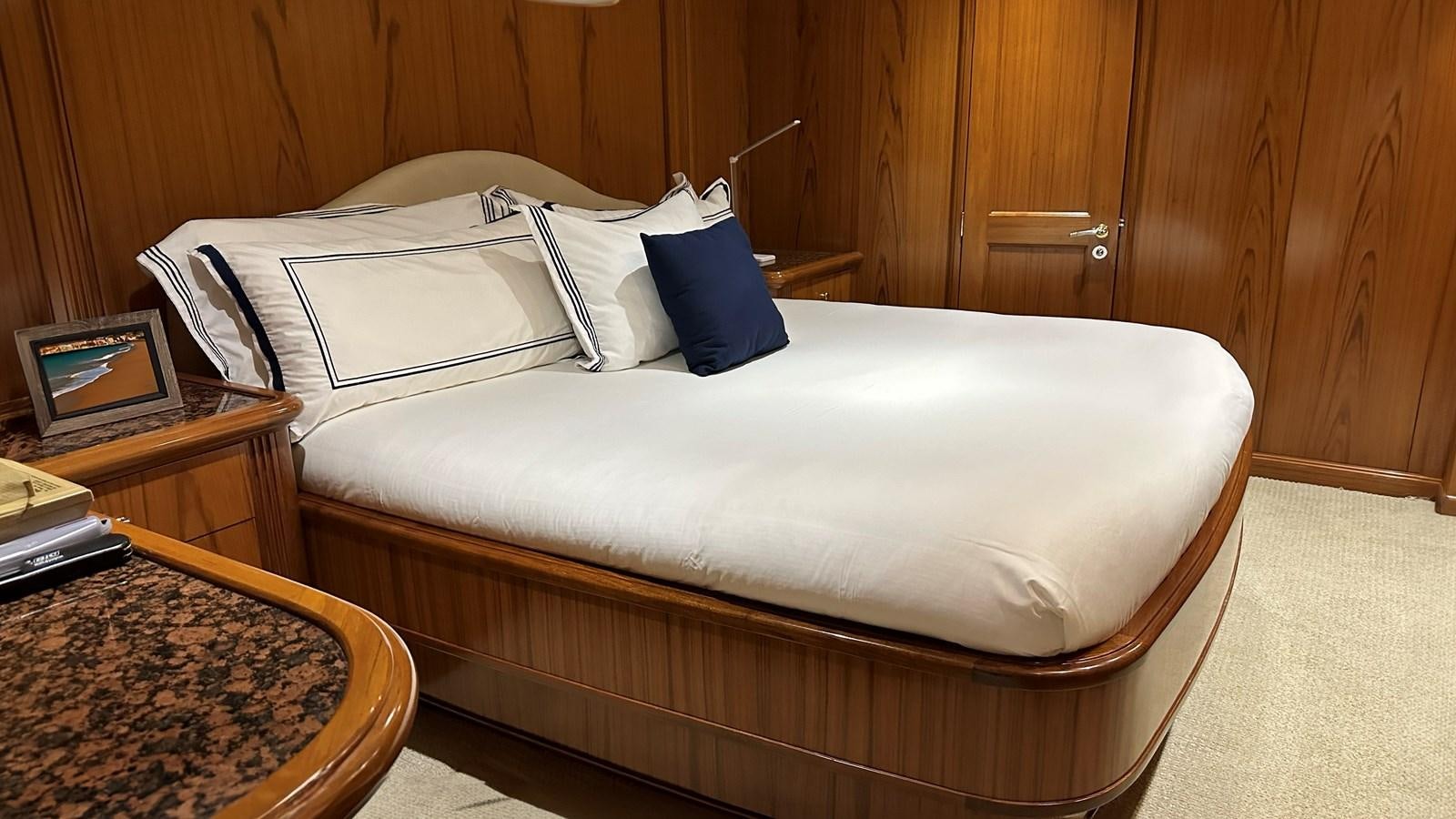 a bed with white sheets and pillows aboard REEL DEAL Yacht for Sale