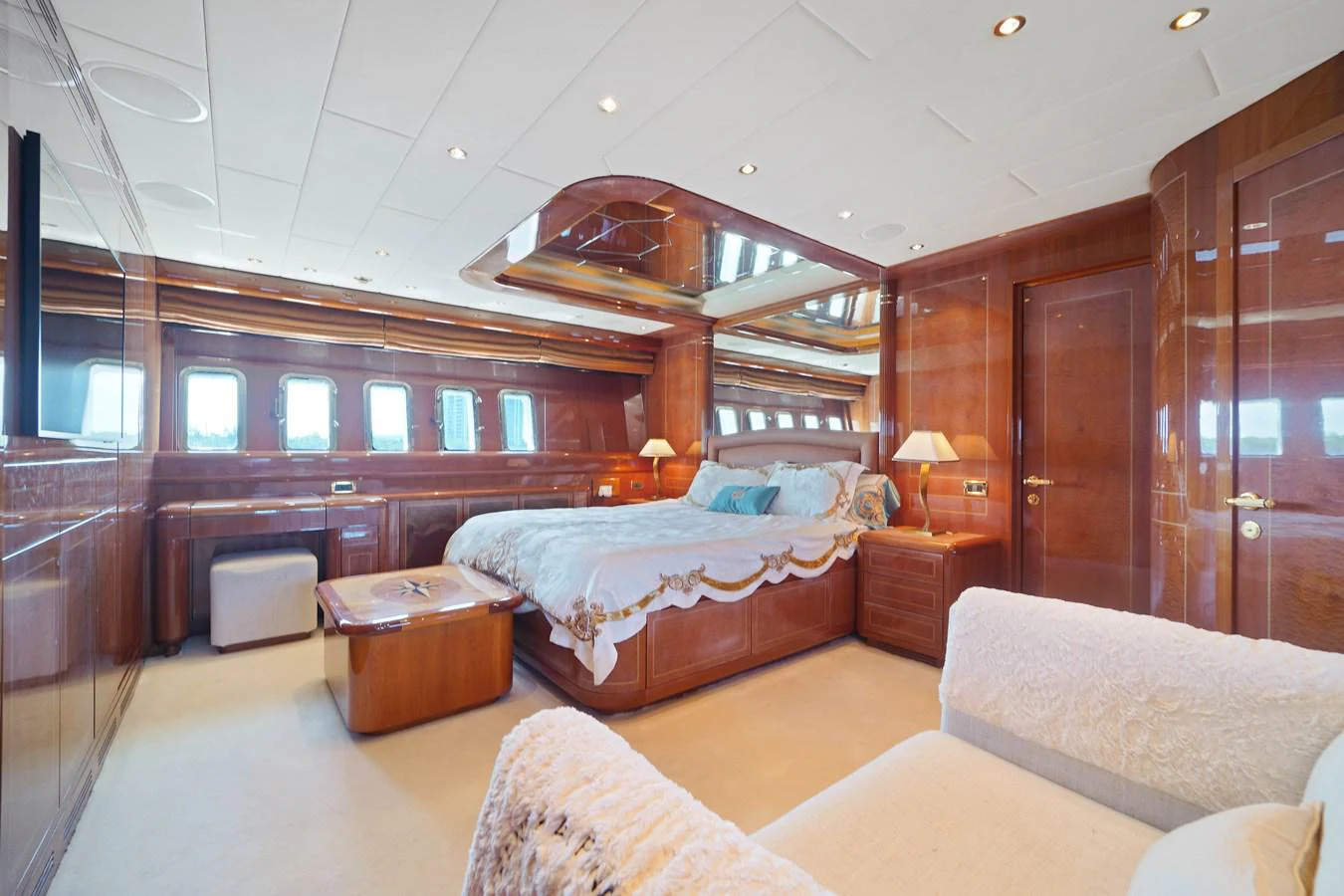 a bedroom with a bed and a table aboard 108' MANGUSTA 2002 Yacht for Sale