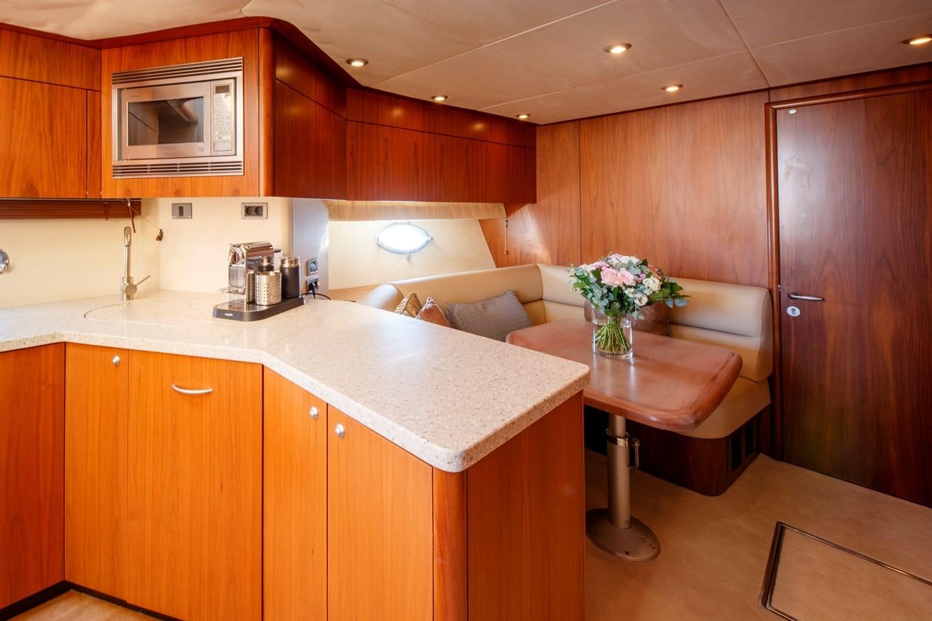 a kitchen with wooden cabinets aboard NUTS Yacht for Sale