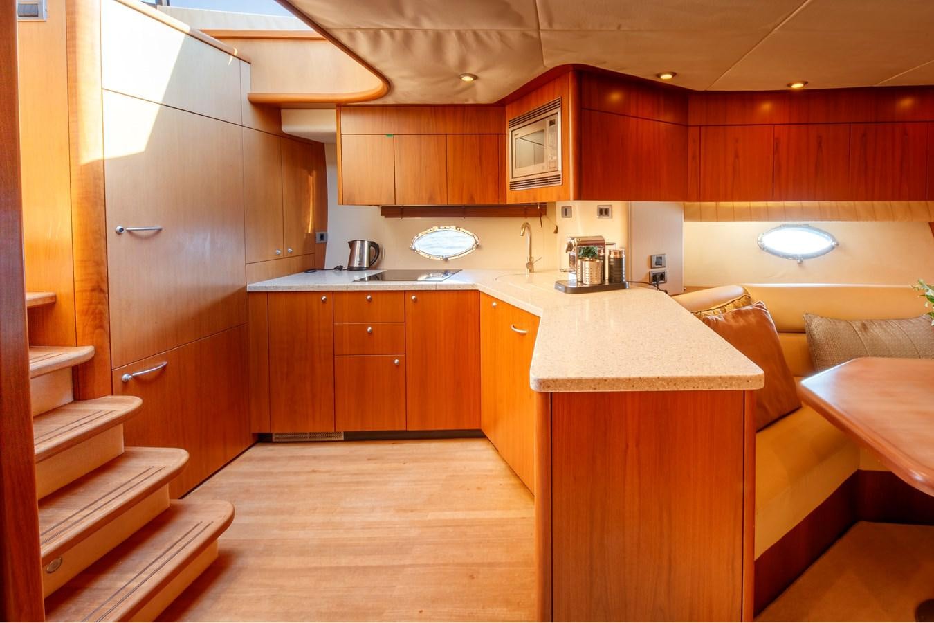 a kitchen with wooden cabinets aboard NUTS Yacht for Sale