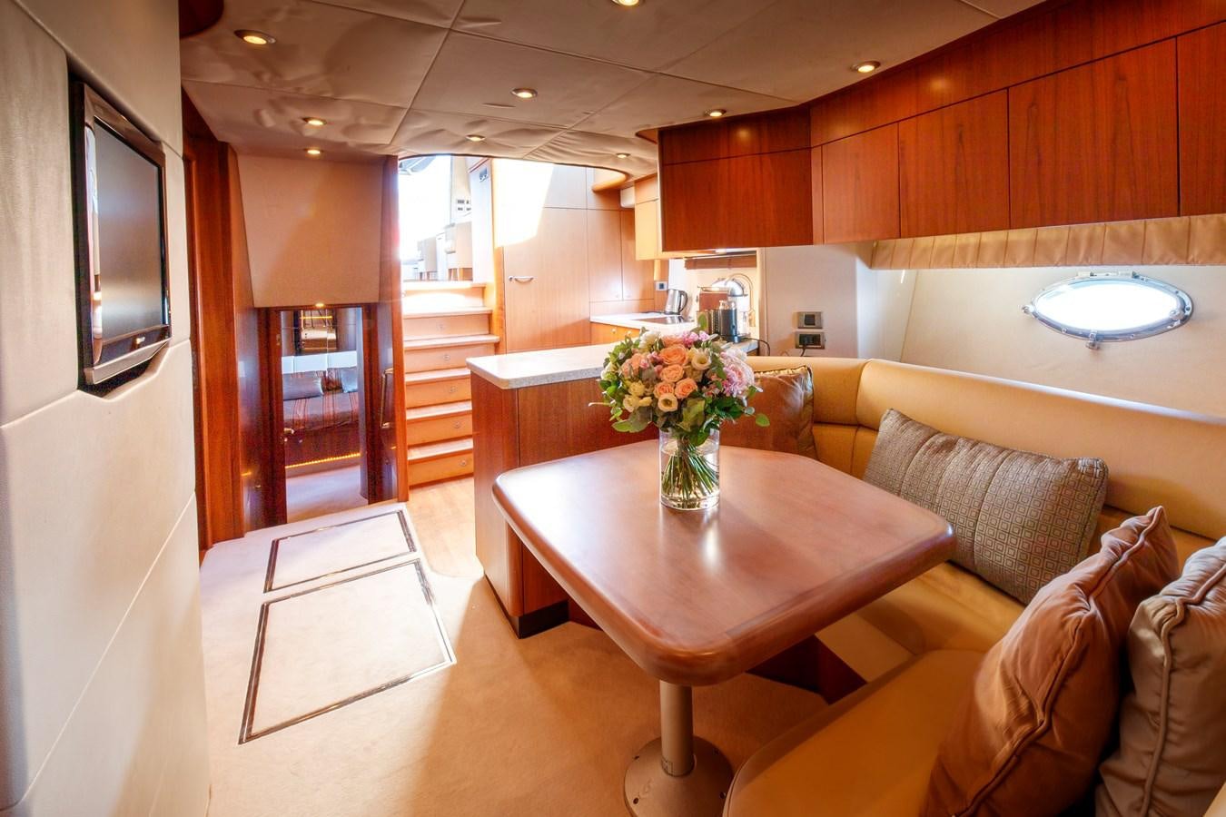 a living room with a table and couches aboard NUTS Yacht for Sale