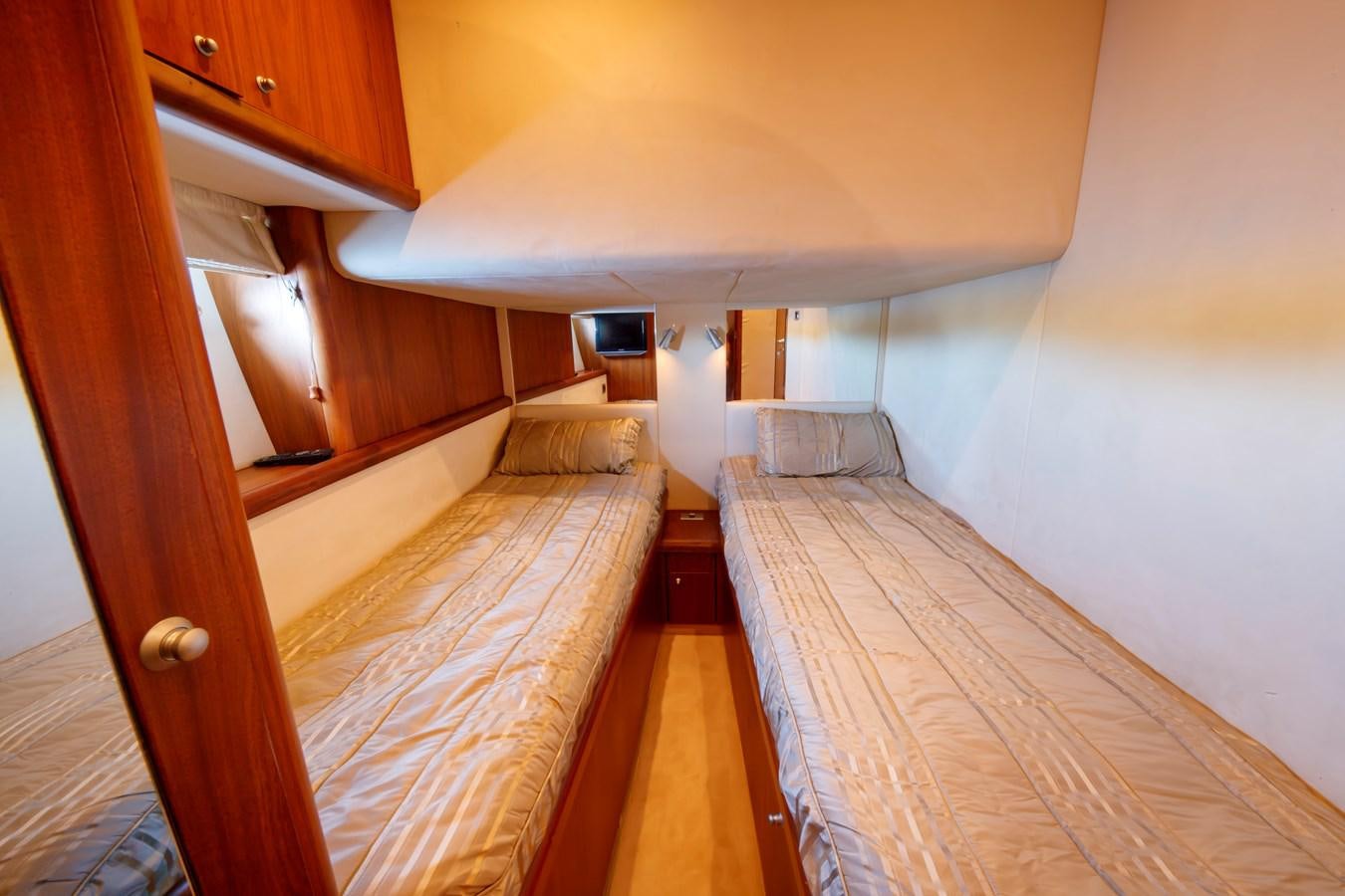 a room with a bed and a wood floor aboard NUTS Yacht for Sale