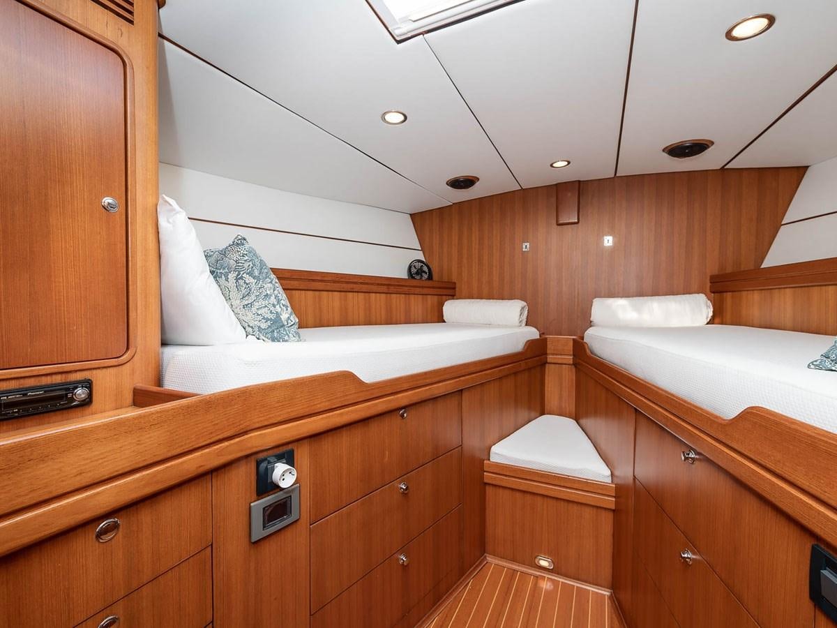 a room with a bed and a wood wall aboard VENTUROUS Yacht for Sale