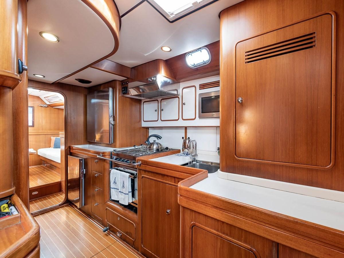 a kitchen with wooden cabinets aboard VENTUROUS Yacht for Sale