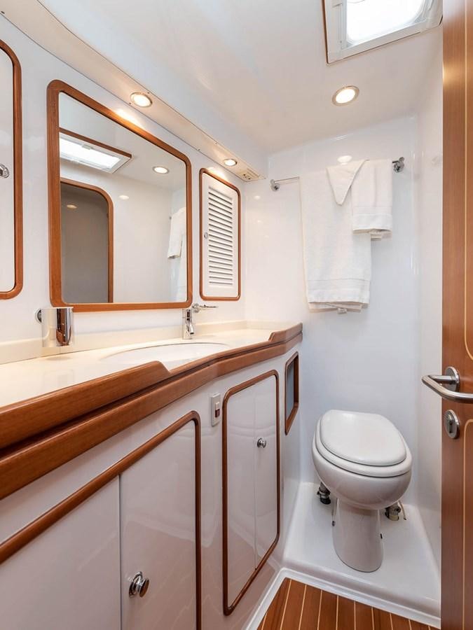 a bathroom with a toilet and a sink aboard VENTUROUS Yacht for Sale