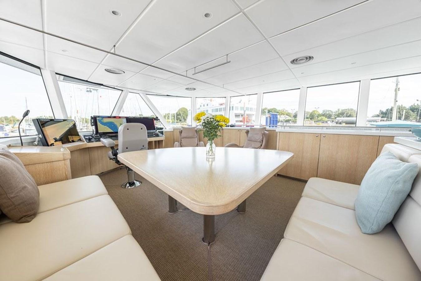 a room with a table and couches aboard GREY WOLF Yacht for Sale