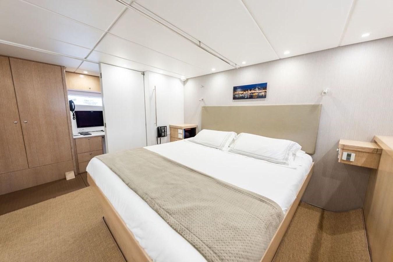 a room with a bed and a wood cabinet aboard GREY WOLF Yacht for Sale