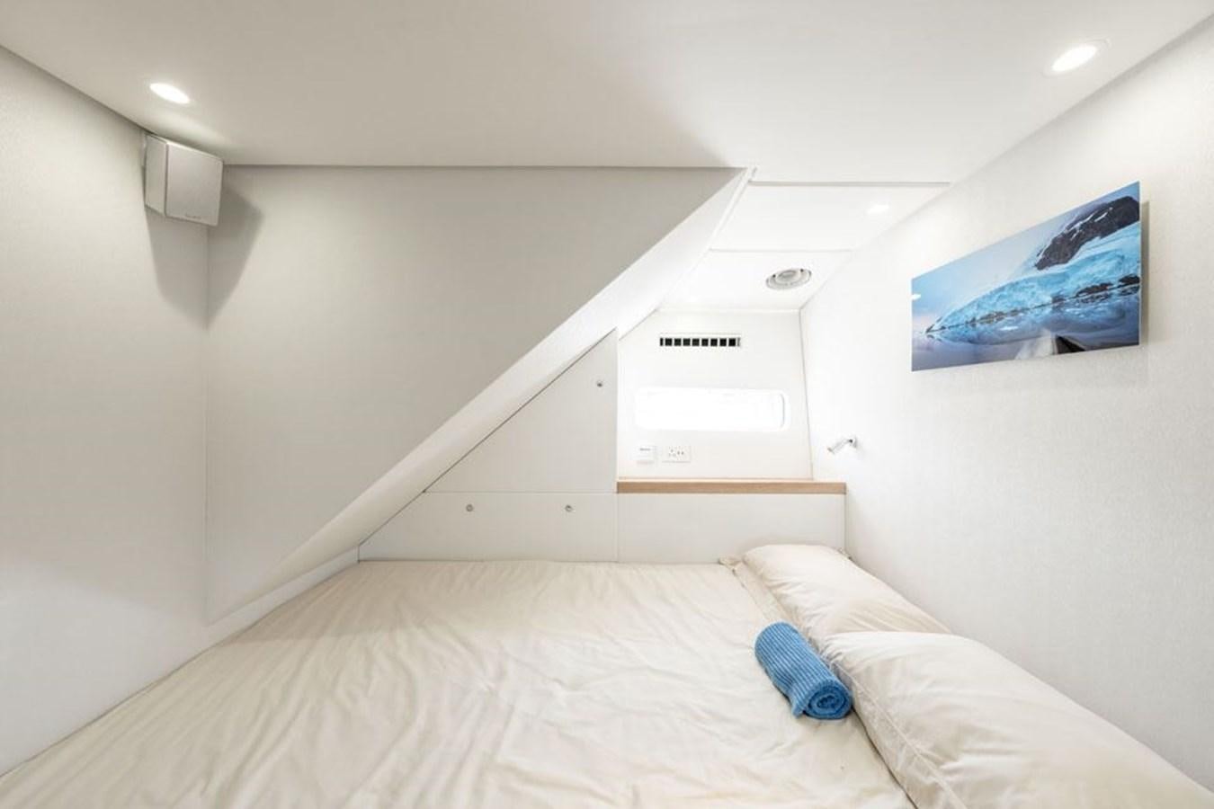a bed with a white bed spread aboard GREY WOLF Yacht for Sale