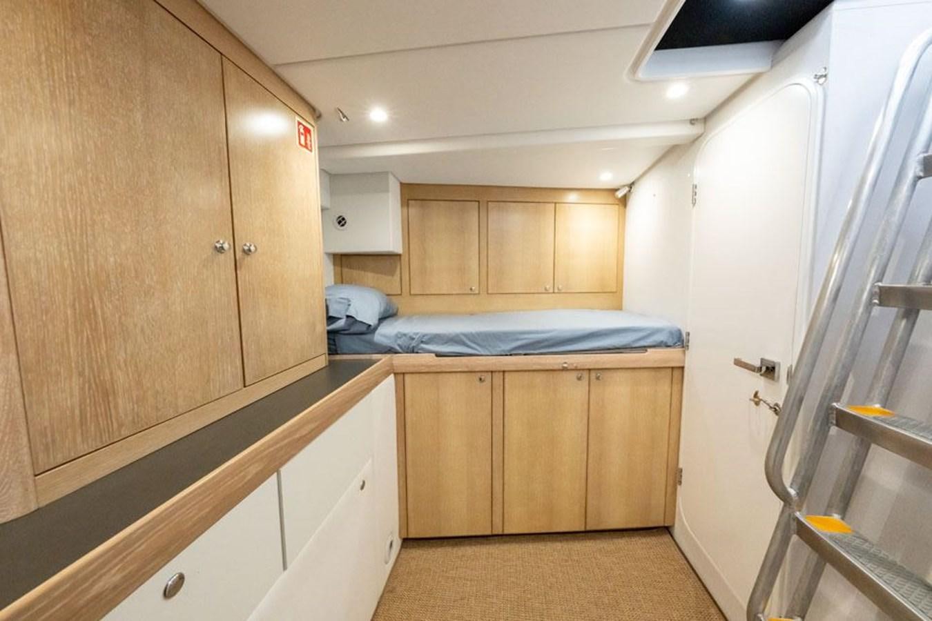 a bedroom with wooden cabinets aboard GREY WOLF Yacht for Sale