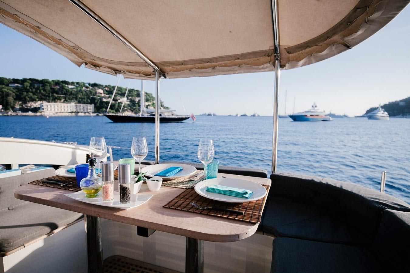 a table with plates and glasses on it by a body of water aboard VINTAGE I Yacht for Sale
