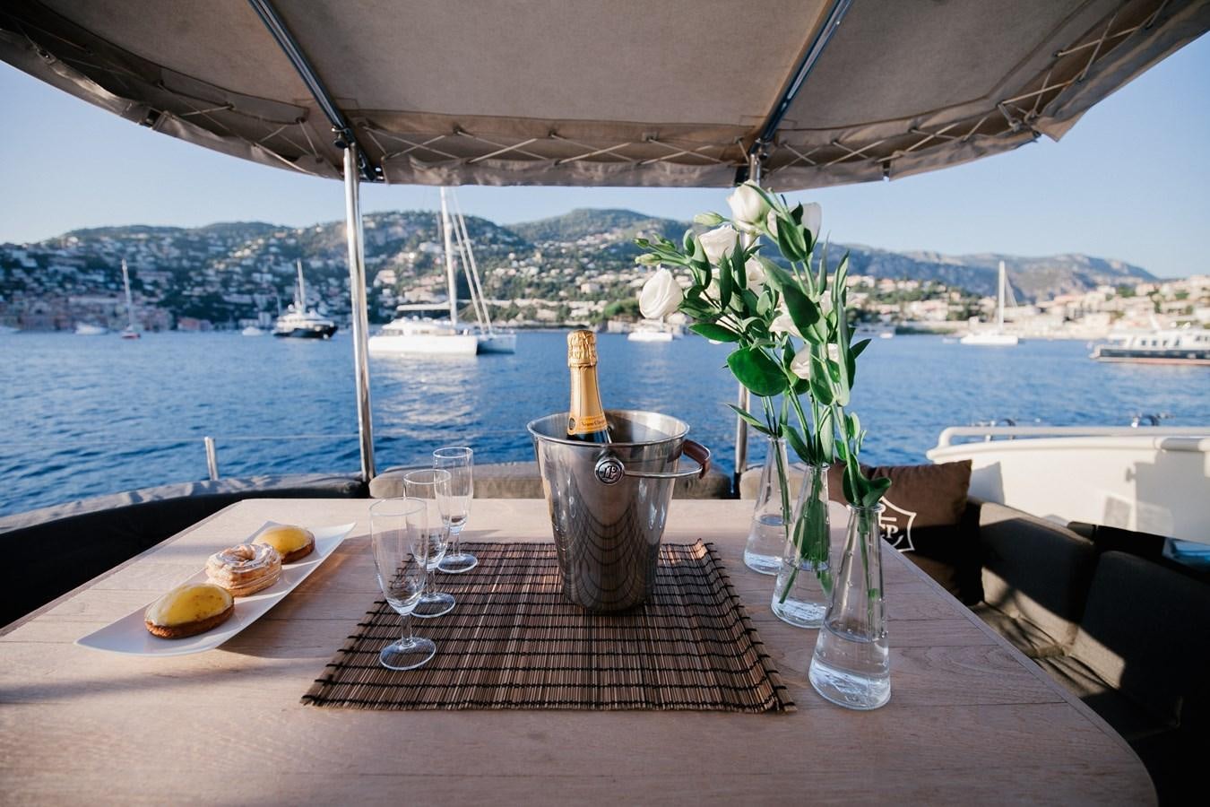 a table with food and glasses on it aboard VINTAGE I Yacht for Sale