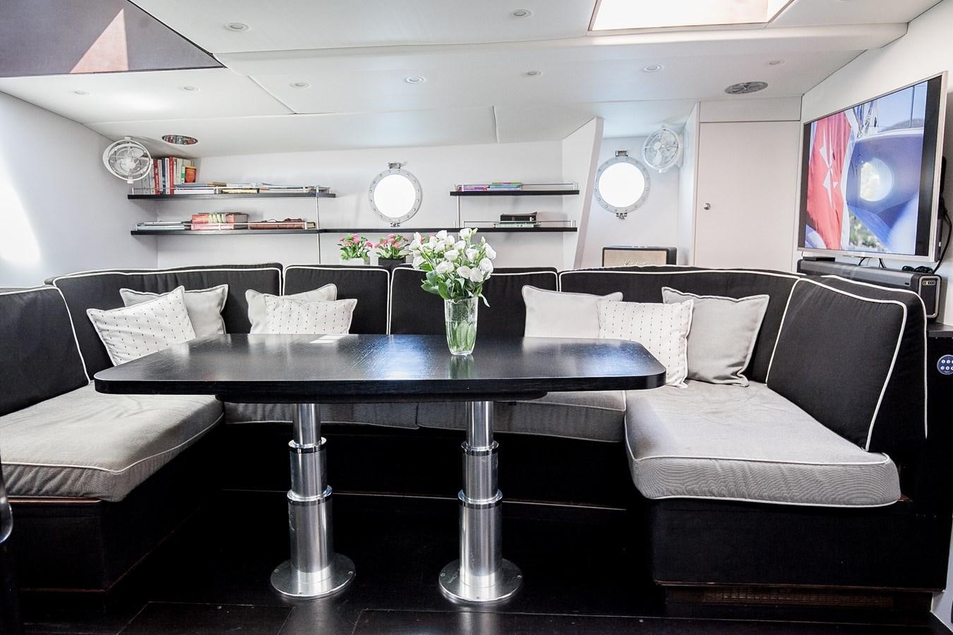 a living room with a table and couches aboard VINTAGE I Yacht for Sale