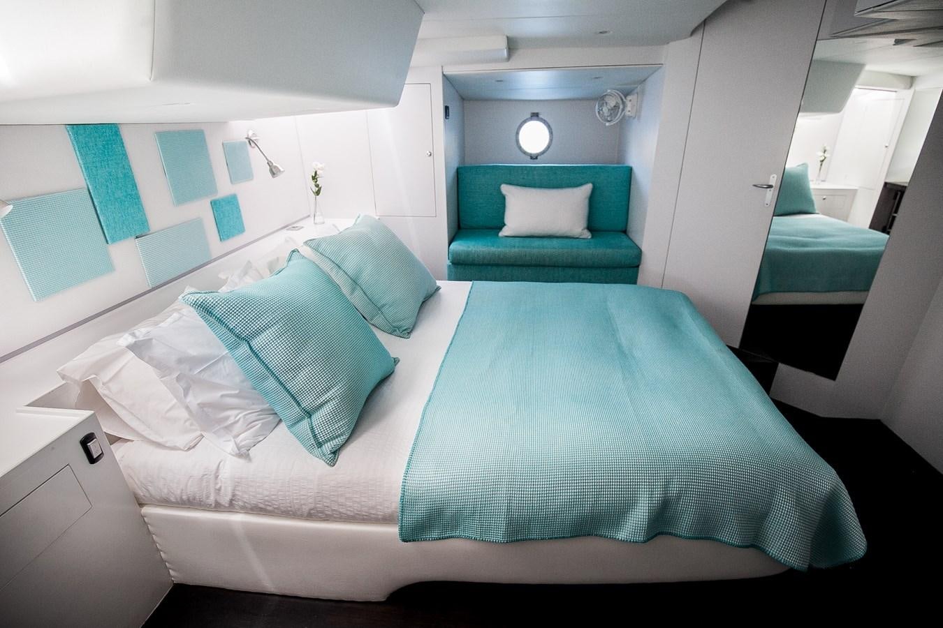 a bed with blue pillows aboard VINTAGE I Yacht for Sale