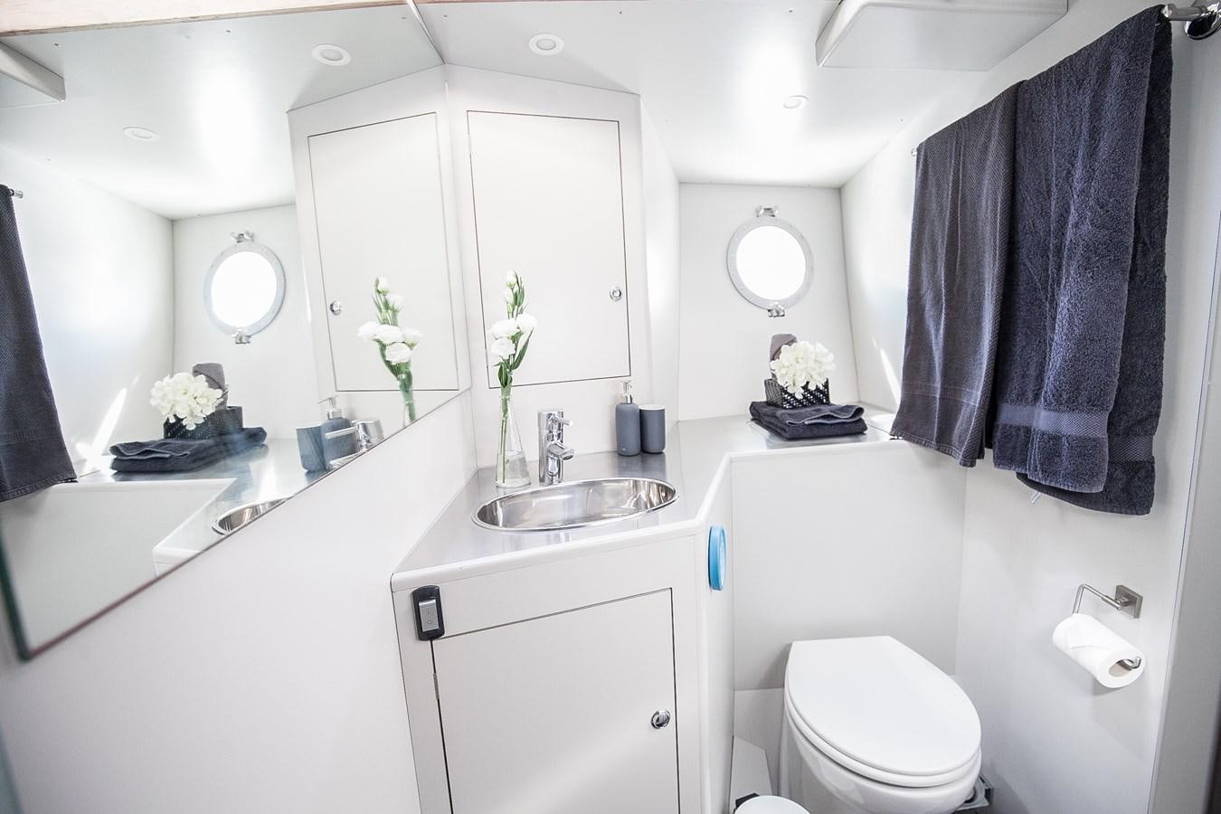 a bathroom with a sink toilet and a mirror aboard VINTAGE I Yacht for Sale