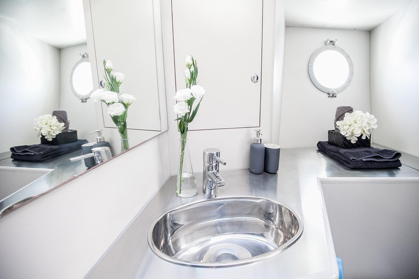 a bathroom with a sink and mirror aboard VINTAGE I Yacht for Sale