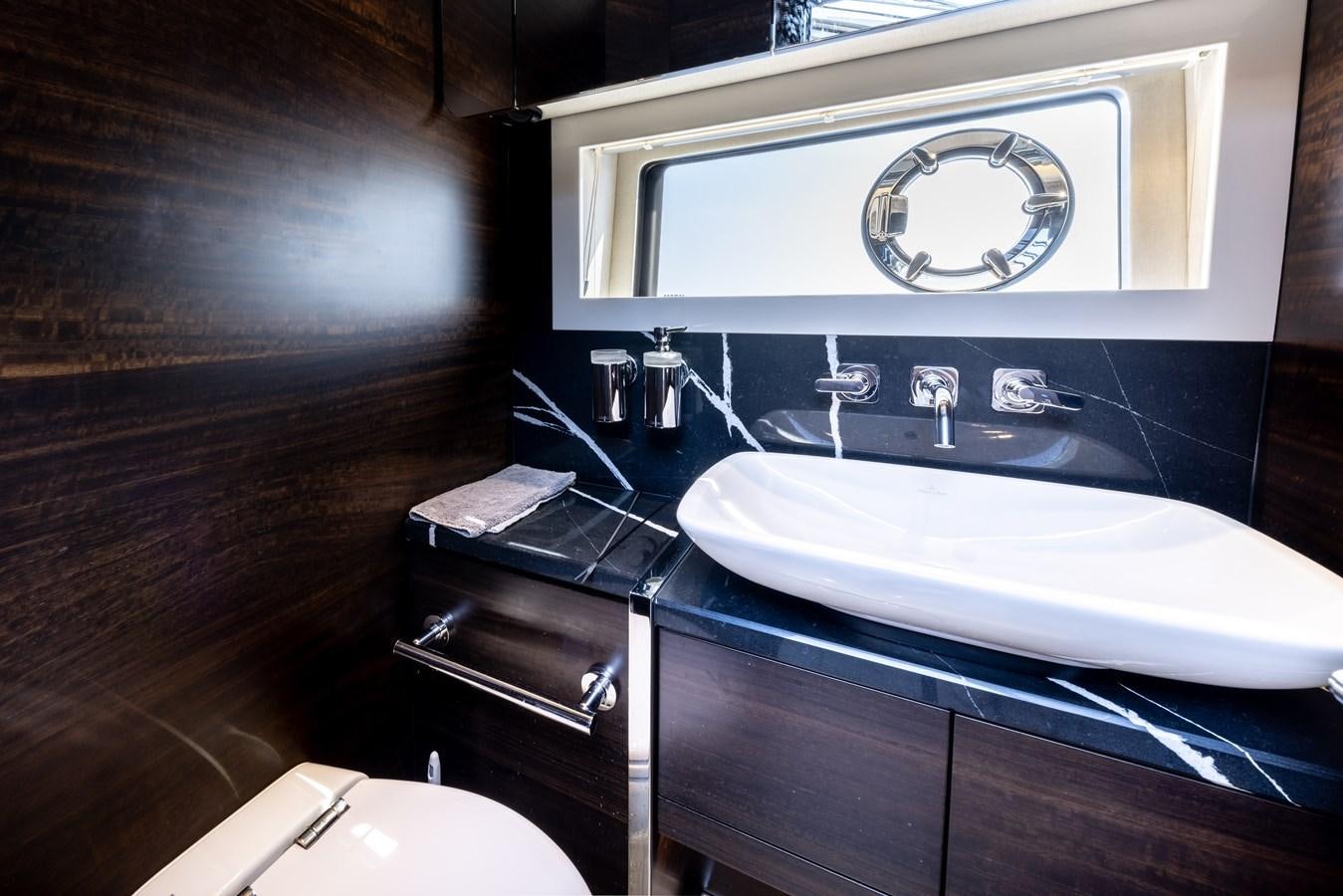 a bathroom with a sink and a large mirror aboard FORZA Yacht for Sale