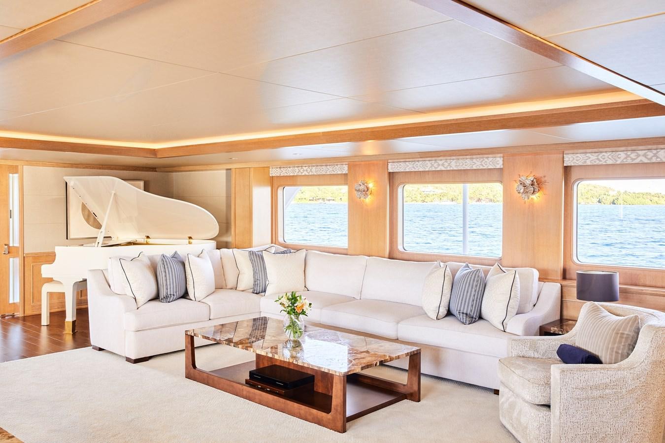 a living room with white couches aboard AMARA Yacht for Sale
