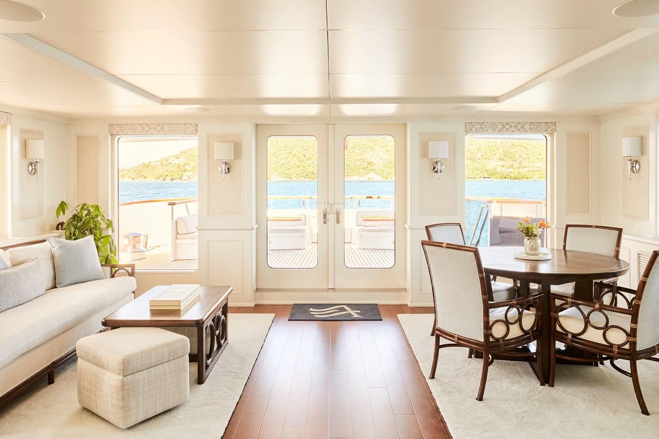 a living room with a table and chairs aboard AMARA Yacht for Sale