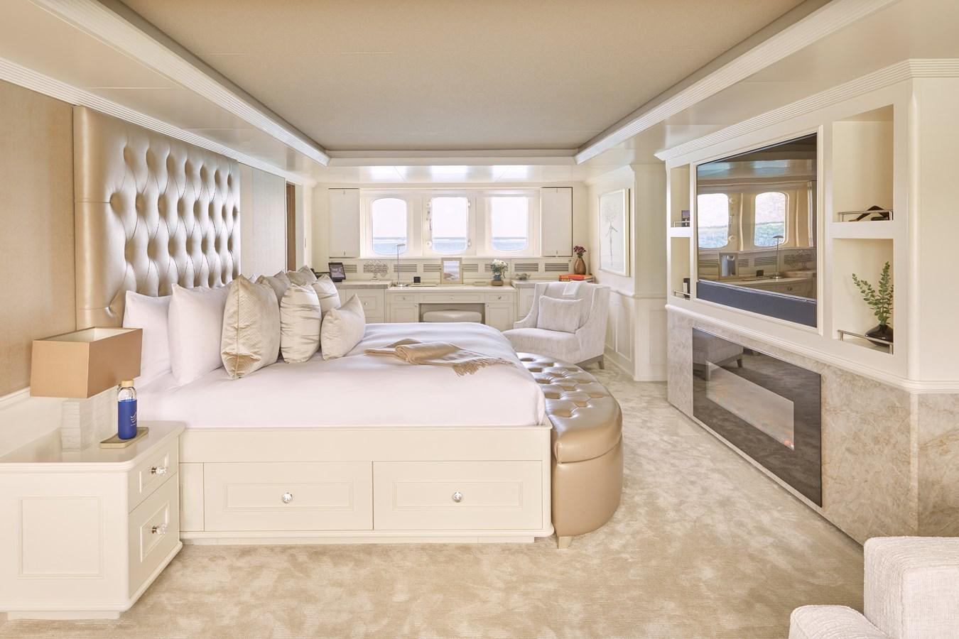 a room with a bed and a fireplace aboard AMARA Yacht for Sale