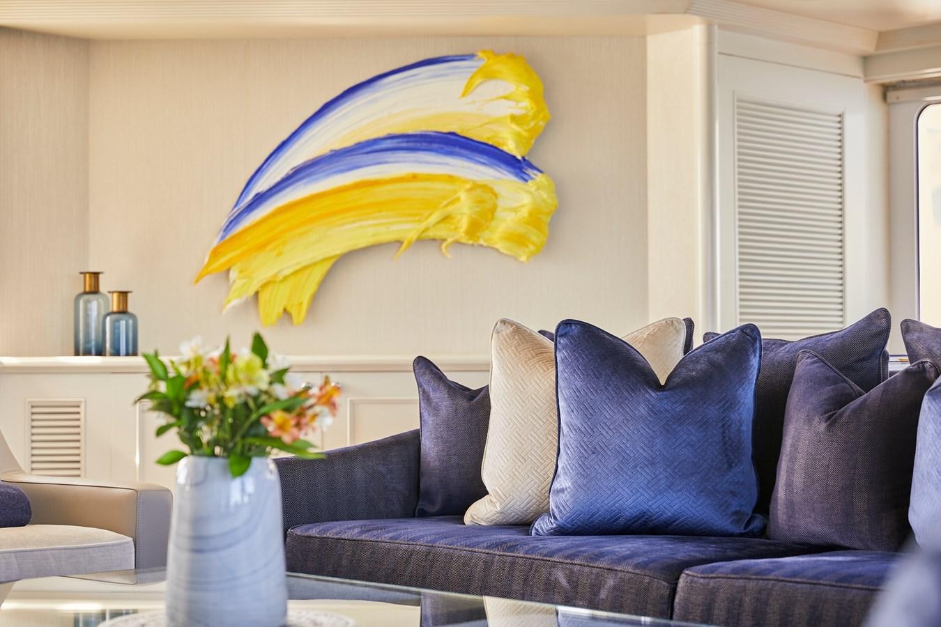 a blue couch with a yellow sun umbrella on it aboard AMARA Yacht for Sale