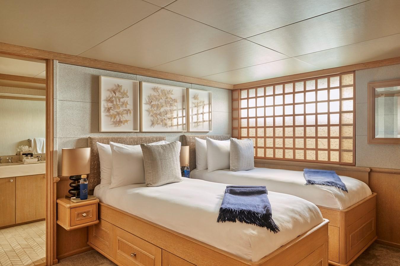 a bed with white sheets and pillows aboard AMARA Yacht for Sale