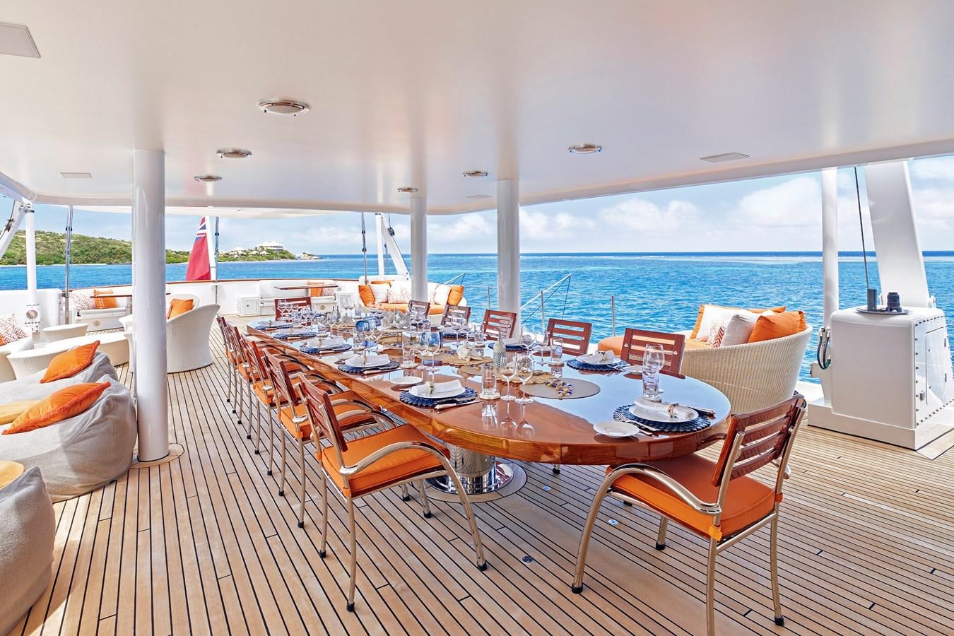 a table set for a meal on a deck overlooking the ocean aboard AMARA Yacht for Sale