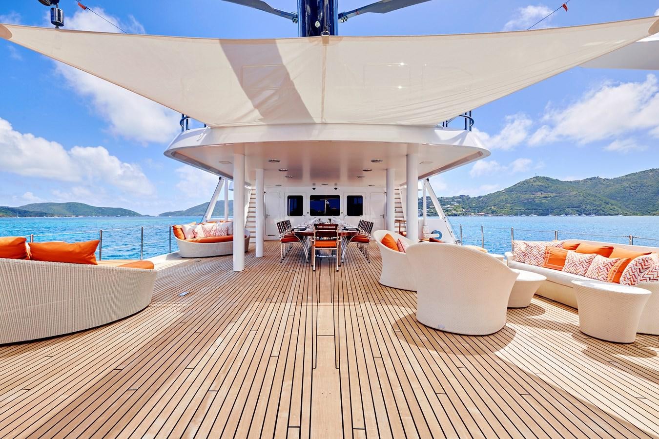 a large white tent with a deck overlooking a body of water aboard AMARA Yacht for Sale