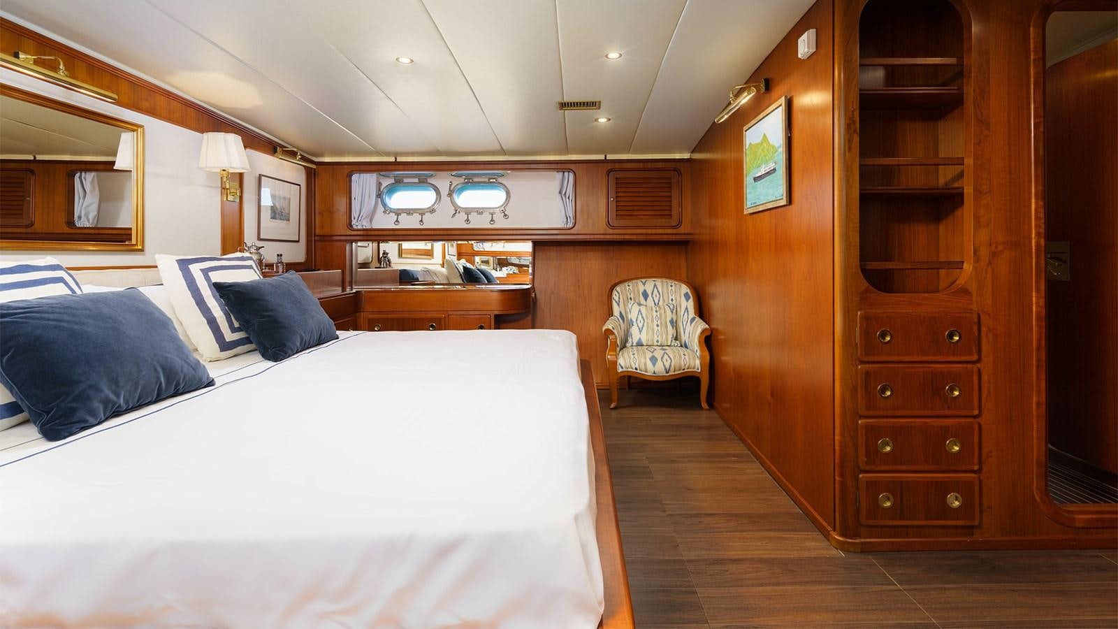 a room with a bed and a chair aboard SPIRIT OF MK Yacht for Sale