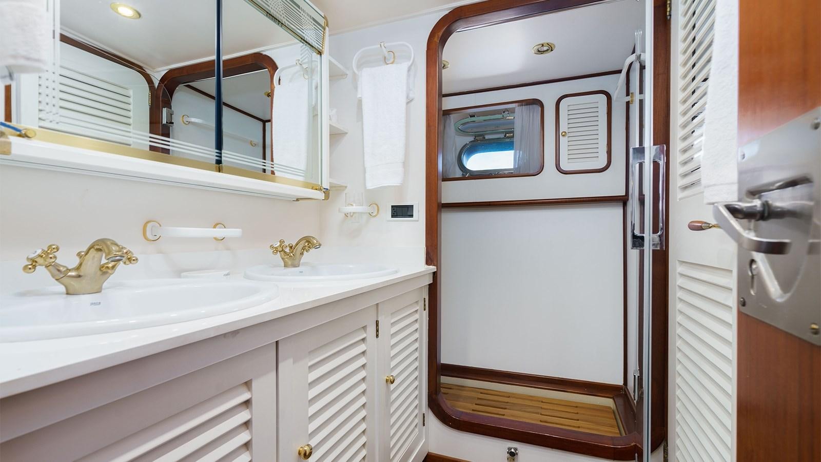 a white cabinet with a sink and a mirror aboard SPIRIT OF MK Yacht for Sale