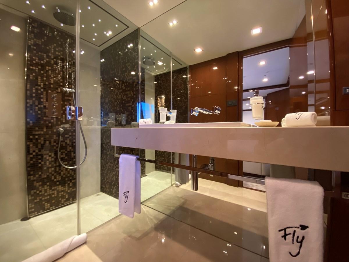 a bathroom with a glass shower aboard FLY Yacht for Sale