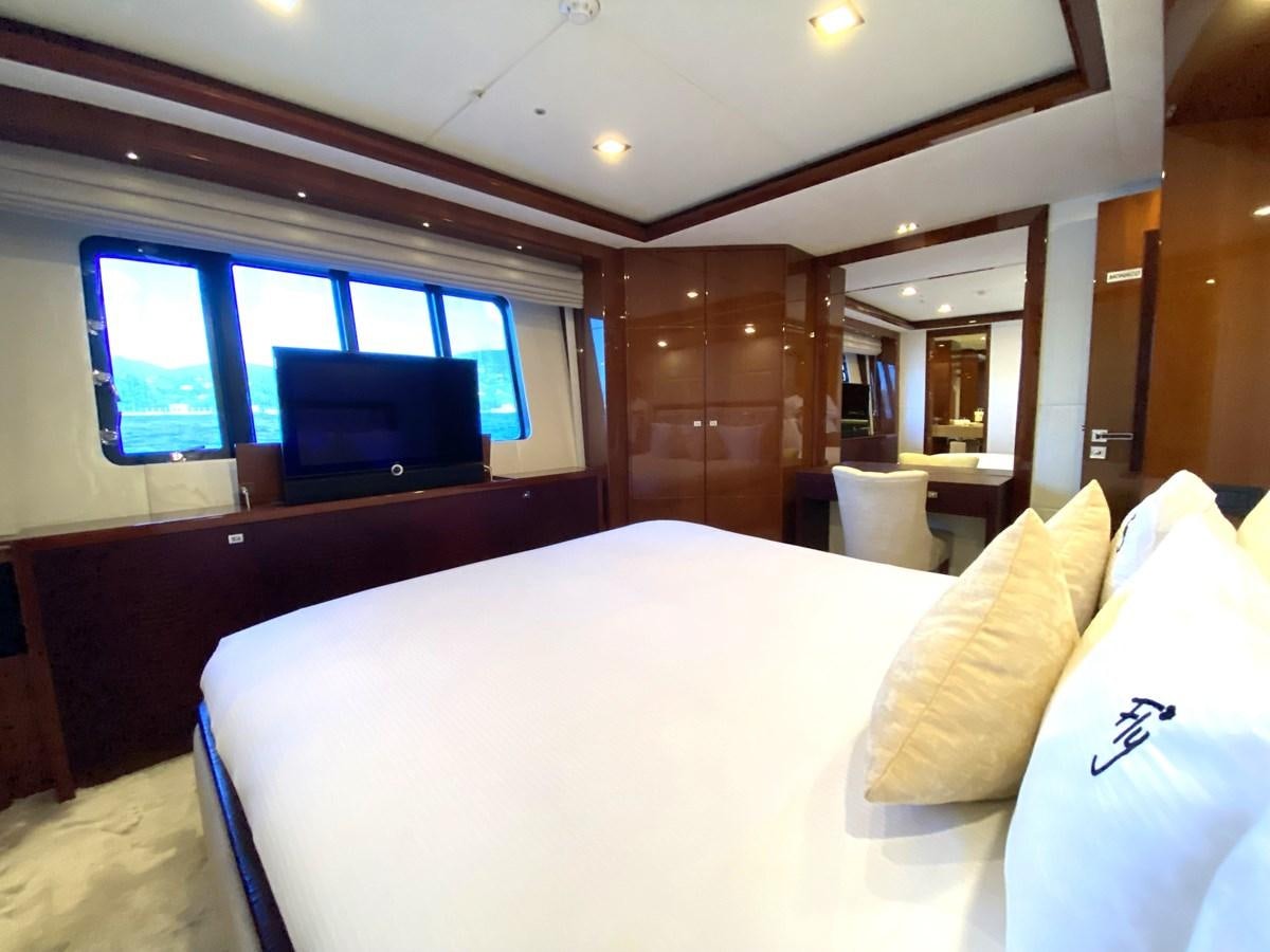 a bed with a television on the wall aboard FLY Yacht for Sale