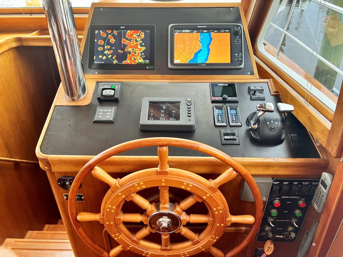 a wooden steering wheel and controls aboard COTYTTO Yacht for Sale