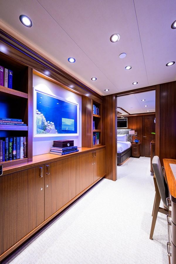 a room with a tv and bookshelves aboard LADY JJ Yacht for Charter