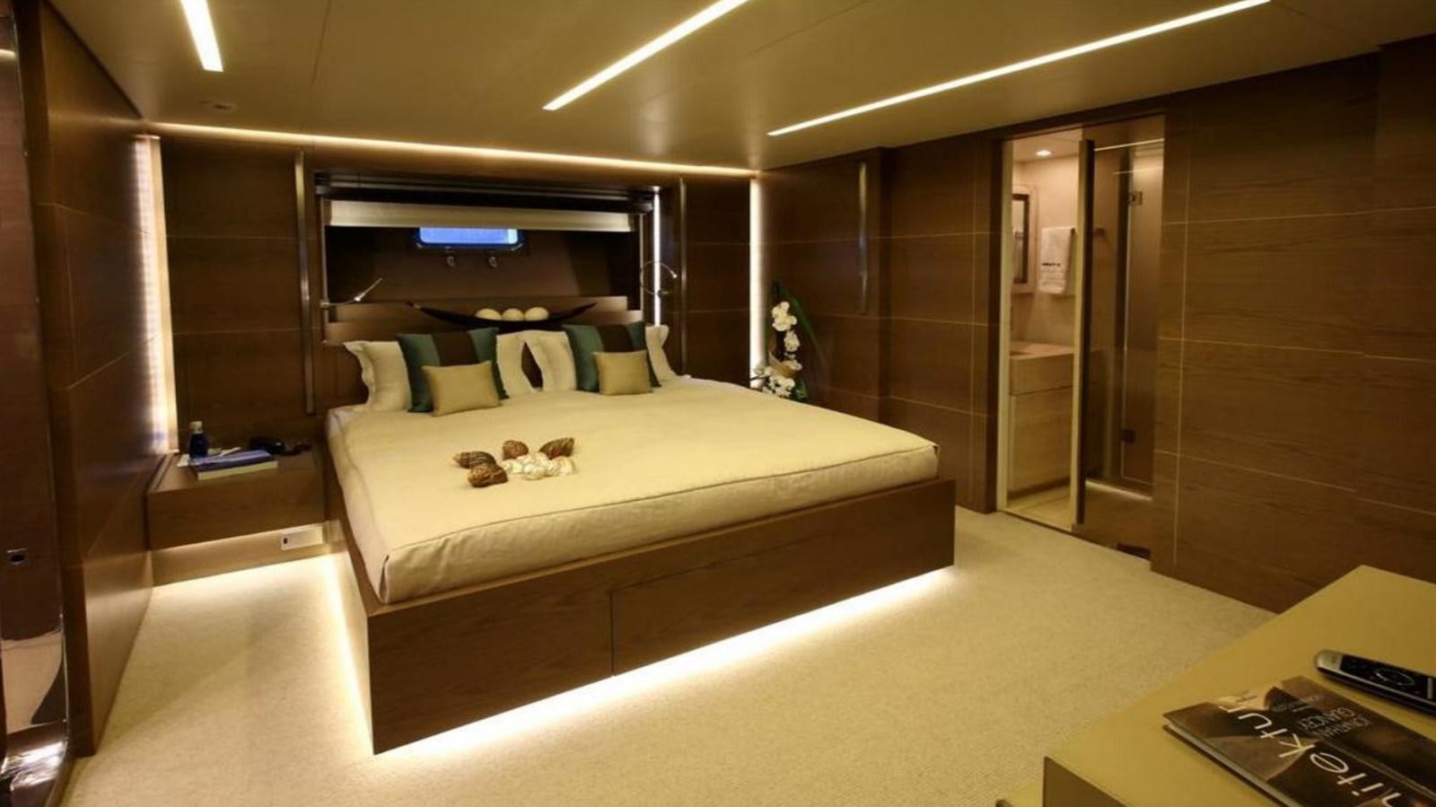 a room with a bed and a desk aboard NAIA Yacht for Sale