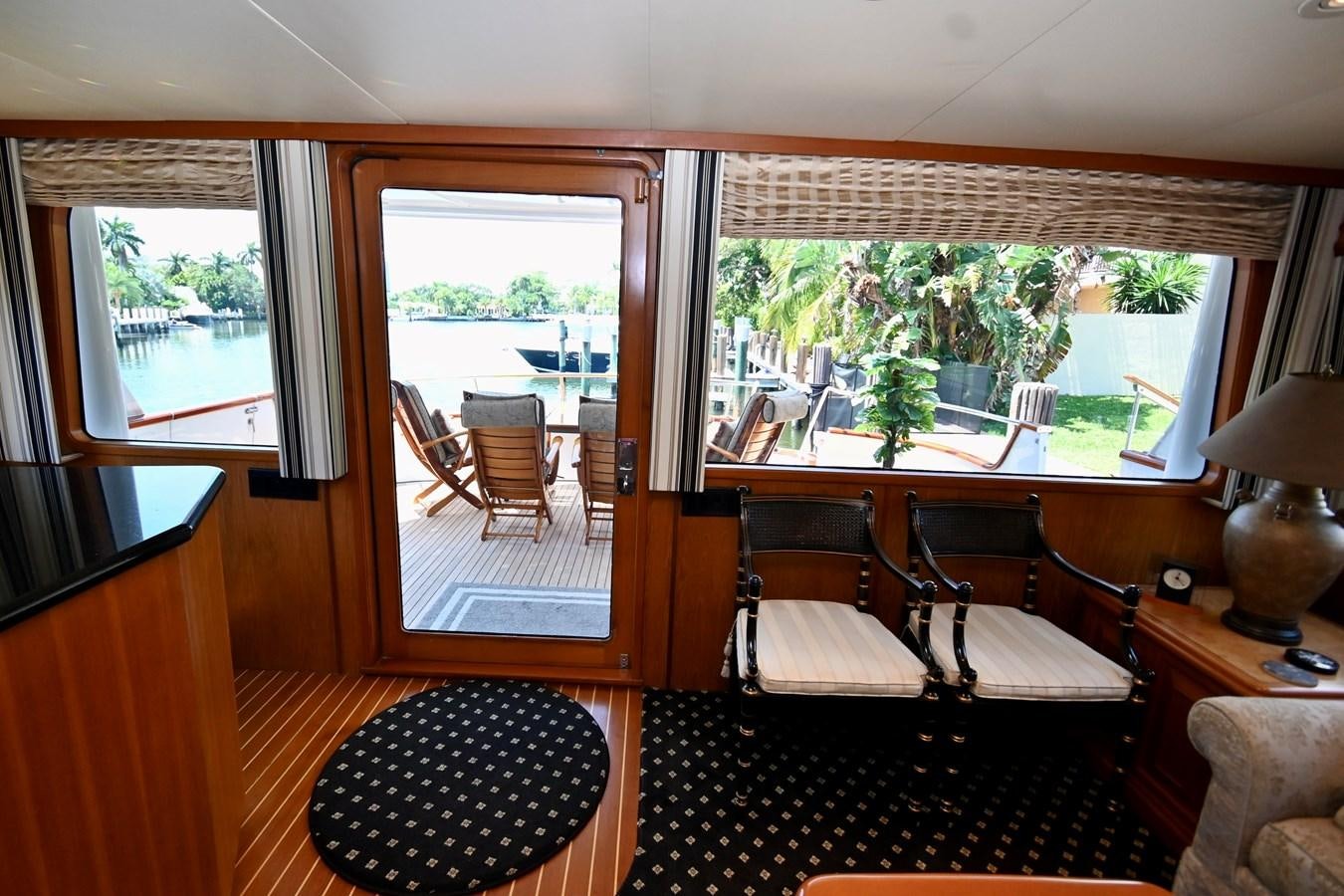 a room with a table chairs and a window aboard CAPTIVATOR Yacht for Sale