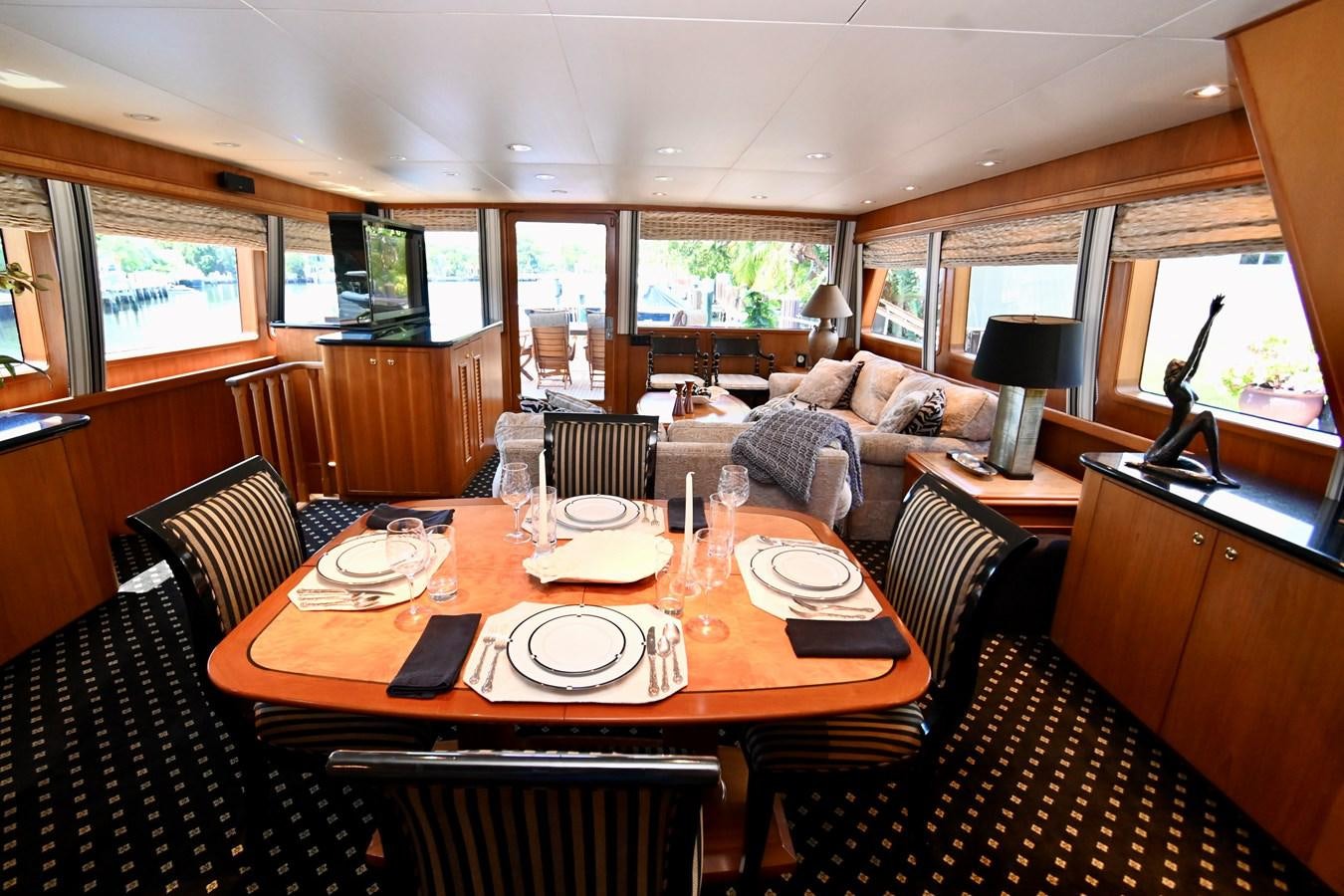a dining table in a living room aboard CAPTIVATOR Yacht for Sale