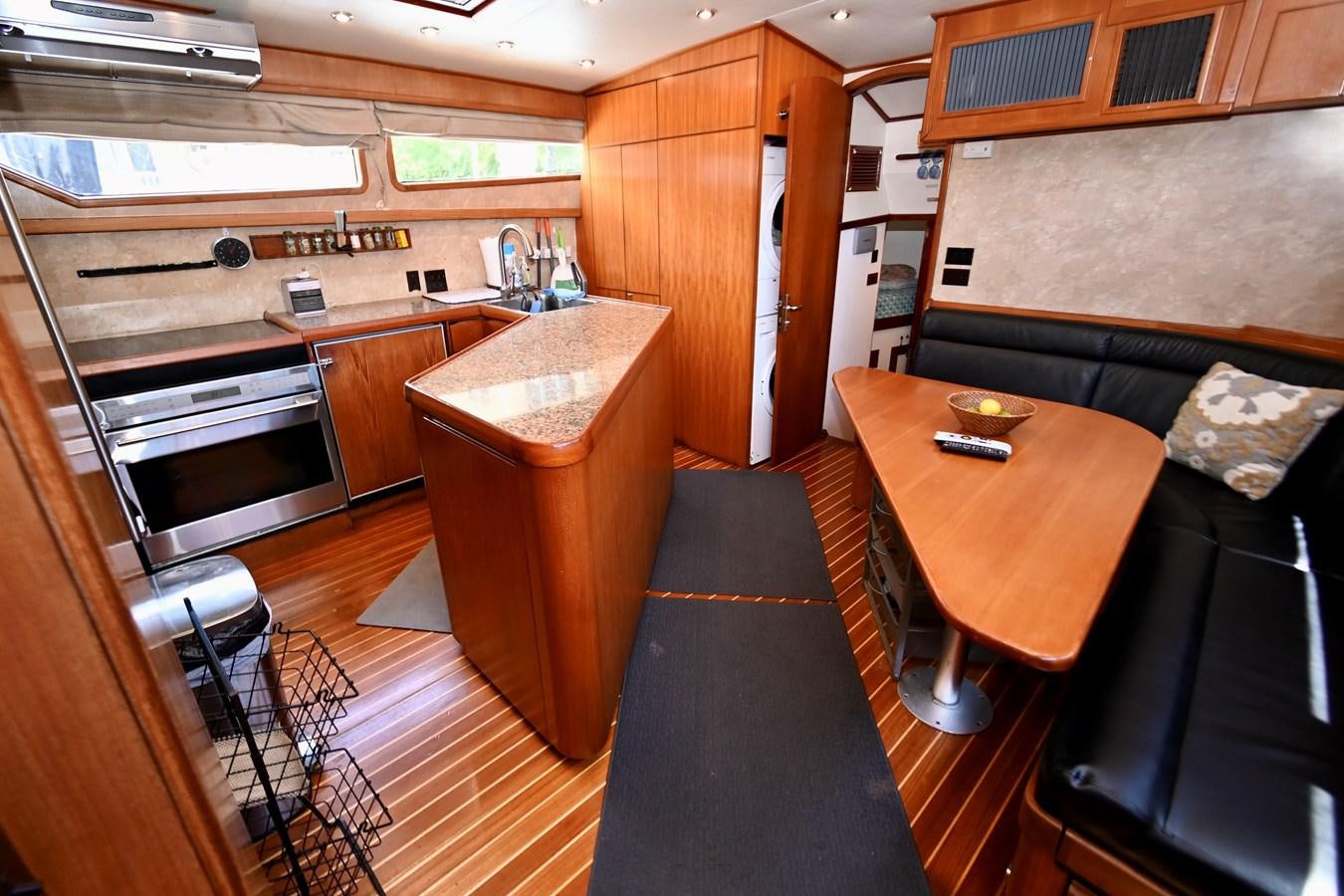 a kitchen with wooden cabinets aboard CAPTIVATOR Yacht for Sale