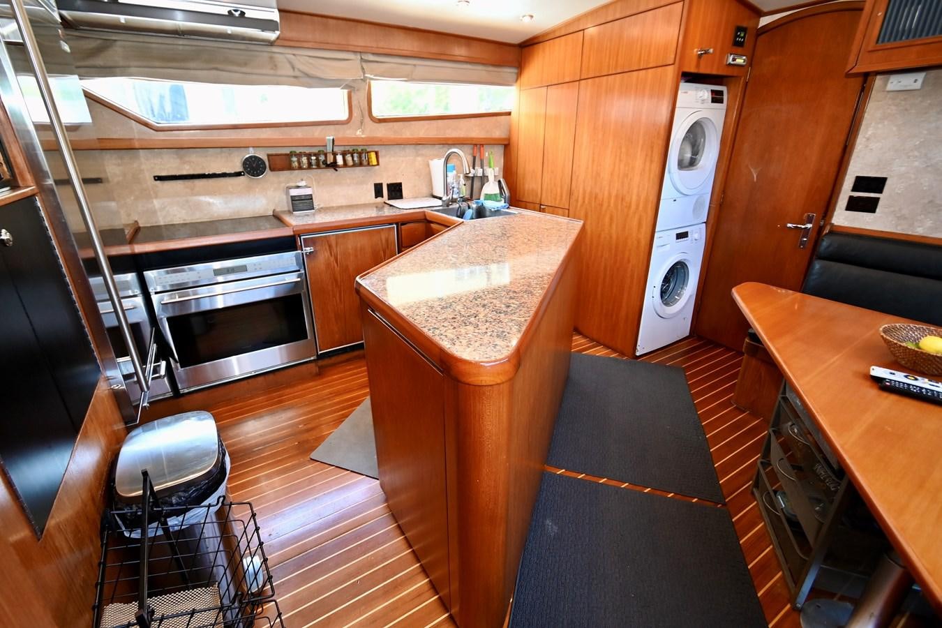 a kitchen with wooden cabinets aboard CAPTIVATOR Yacht for Sale