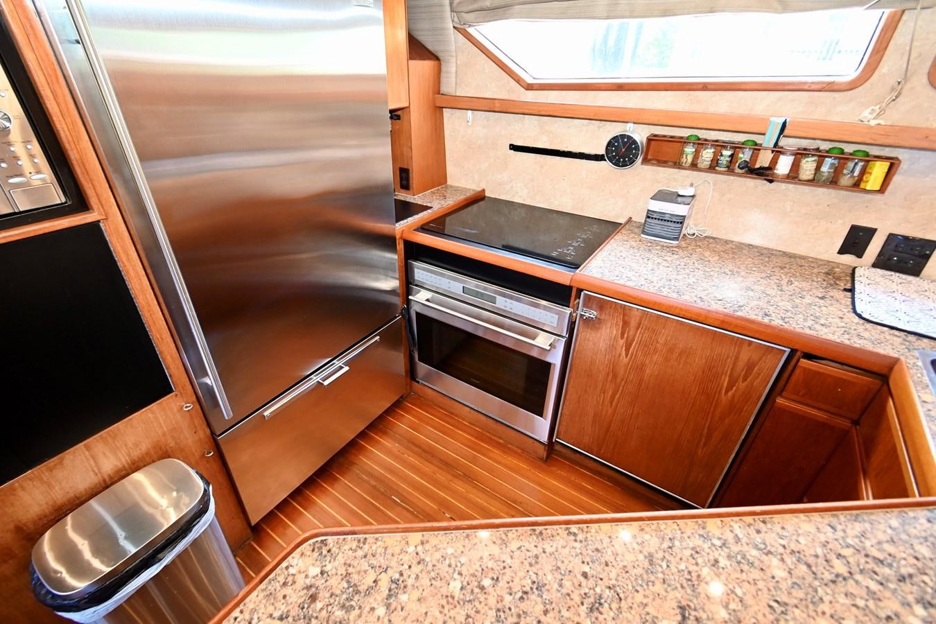 a kitchen with wooden cabinets aboard CAPTIVATOR Yacht for Sale