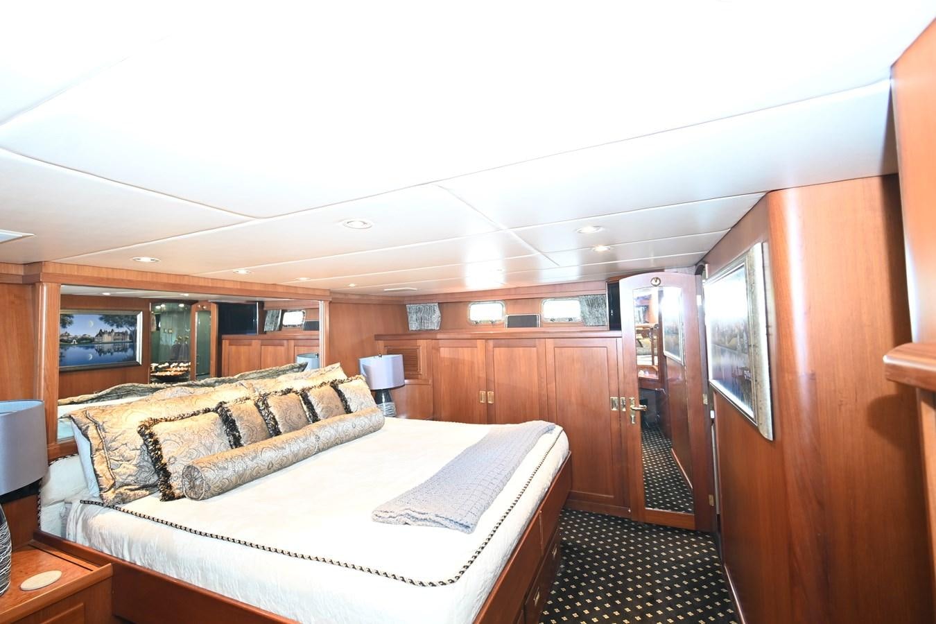 a bedroom with a bed and a mirror aboard CAPTIVATOR Yacht for Sale