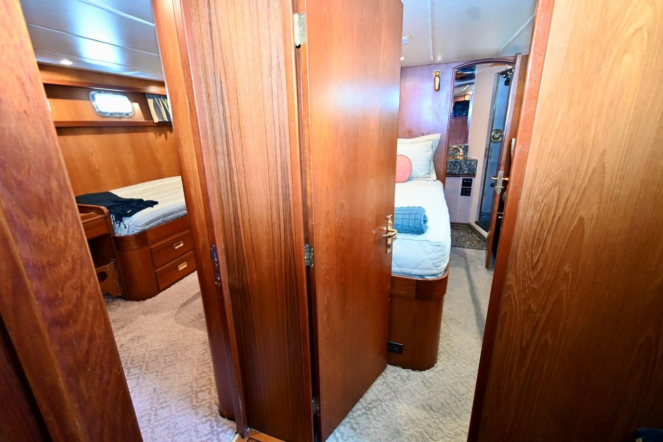 a room with a bed and a closet aboard CAPTIVATOR Yacht for Sale