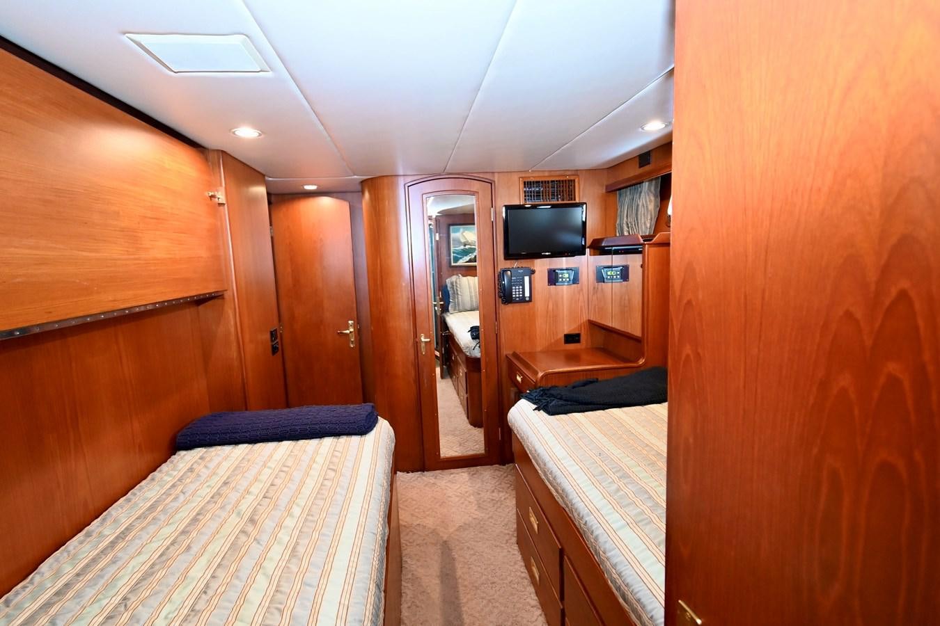 a room with a bed and a television aboard CAPTIVATOR Yacht for Sale